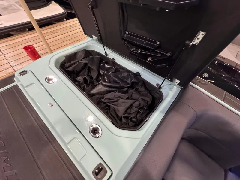 Slide: The Image of 2025 Moomba Max boat storage compartment with black cover inside. - 42