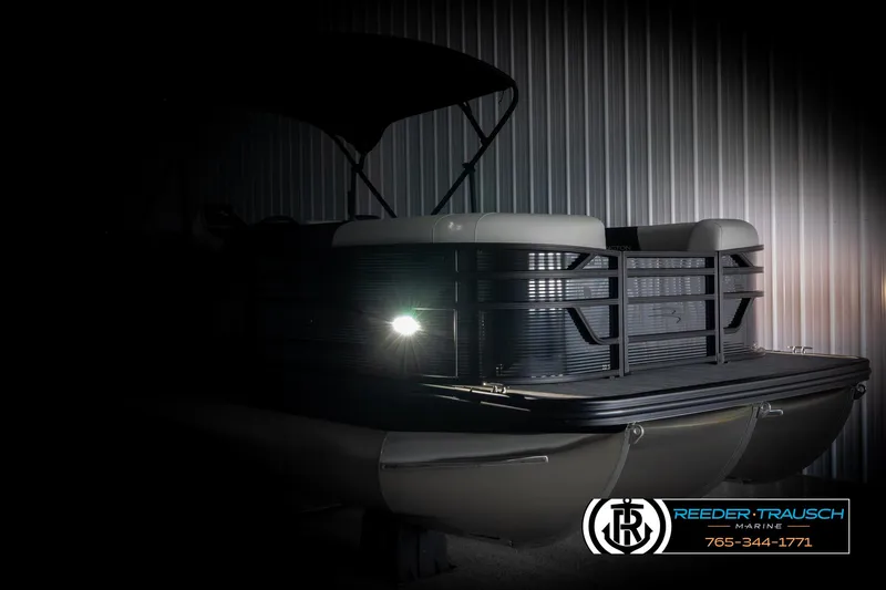 Slide: The Image of 2025 Bennington 22 SSRSE pontoon boat in dimly lit showroom, highlighting sleek design. - 4