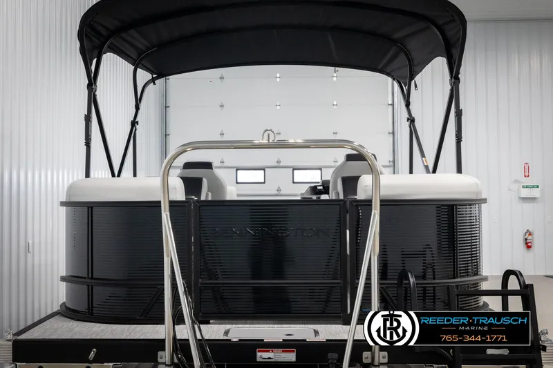 Slide: The Image of 2025 Bennington 22 SSRSE pontoon boat in a showroom, featuring sleek black design. - 7