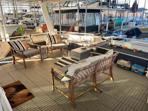 Slide: The Image of Outdoor seating area on a 2005 Sumerset 90x18 houseboat, featuring stylish furniture and marina views. - 11