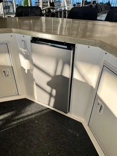 Slide: The Image of 2005 Sumerset 90x18 houseboat interior with compact fridge and storage cabinets. - 16