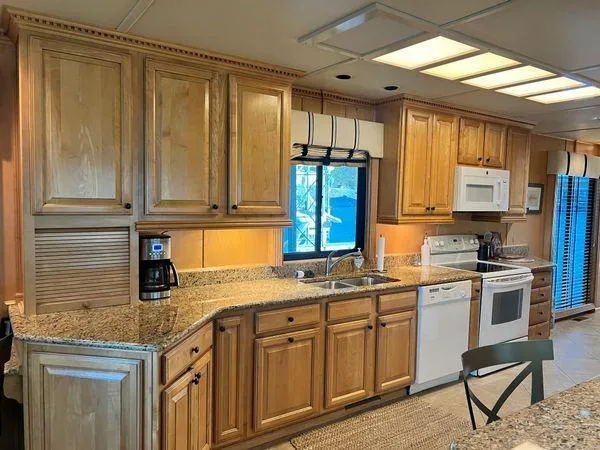Slide: The Image of Kitchen interior of 2005 Sumerset 90x18 houseboat with wooden cabinets and modern appliances. - 29