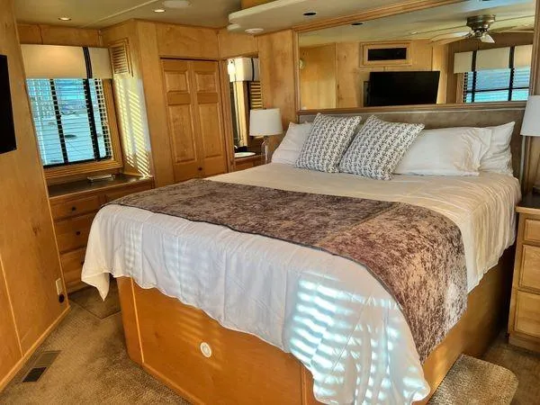 Slide: The Image of Luxurious bedroom interior of a 2005 Sumerset 90x18 houseboat with cozy bedding and wooden decor. - 41