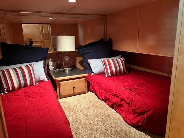 Slide: The Image of Twin beds with red bedding in a 2005 Sumerset 90x18 houseboat cabin. - 43