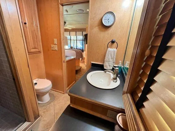 Slide: The Image of 2005 Sumerset 90x18 houseboat bathroom with sink, toilet, and wooden cabinetry. - 46