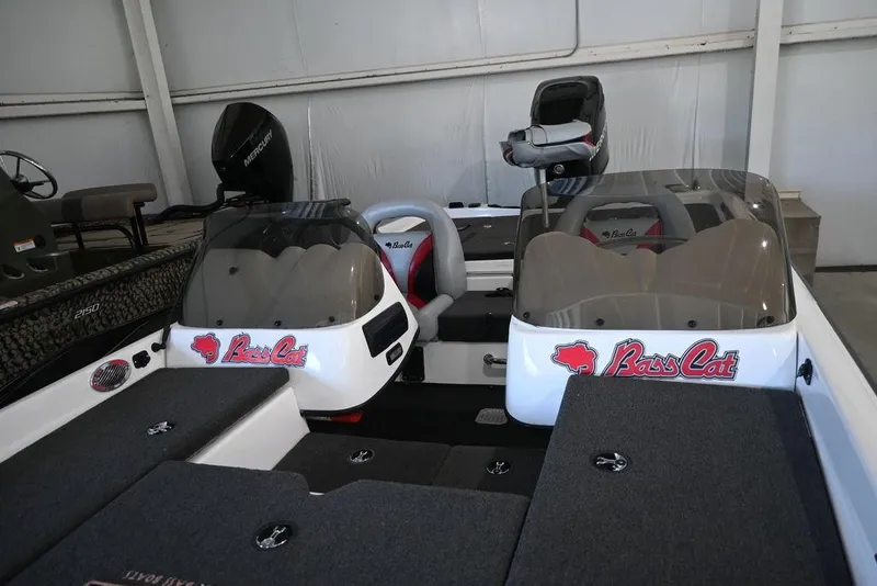Slide: The Image of 2006 Bass Cat Puma boat interior with dual consoles and seating in a showroom. - 5