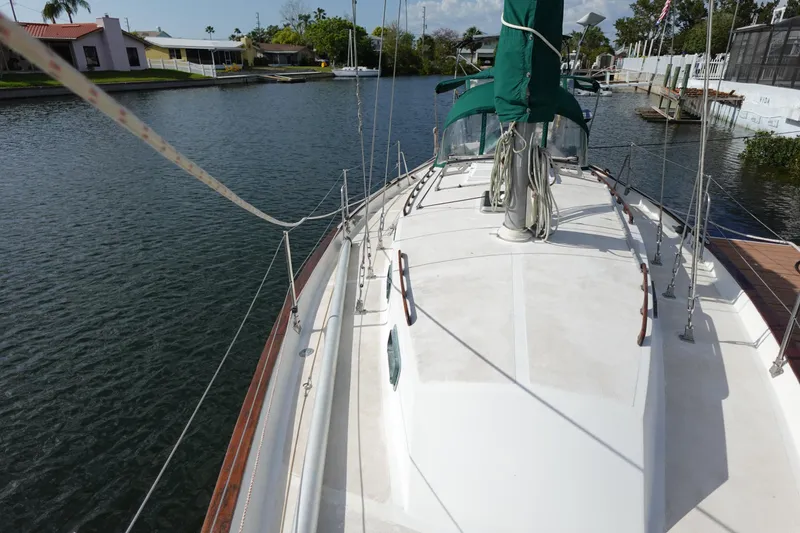 Slide: The Image of 1982 Morgan 383 sailboat docked in a serene canal setting. - 11