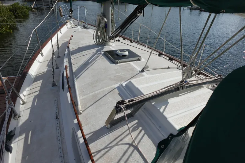 Slide: The Image of 1982 Morgan 383 sailboat deck with rigging, docked by the water. - 12