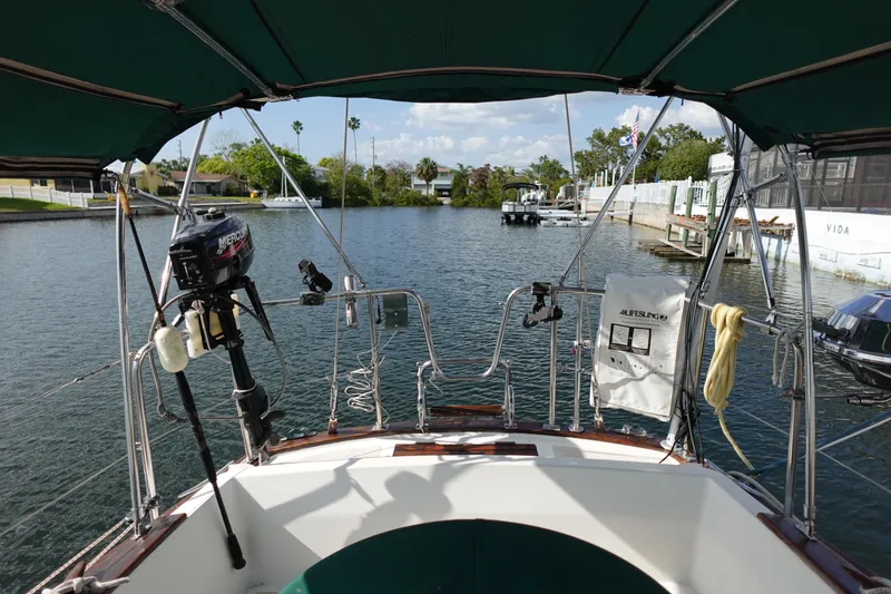 Slide: The Image of 1982 Morgan 383 sailboat cockpit view, docked in a serene marina setting. - 14
