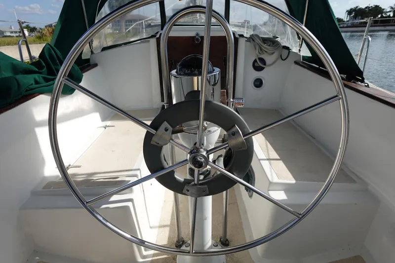 Slide: The Image of 1982 Morgan 383 sailboat cockpit with steering wheel and nautical equipment. - 16