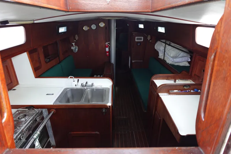 Slide: The Image of Interior of 1982 Morgan 383 sailboat with kitchen, seating, and wooden finishes. - 22