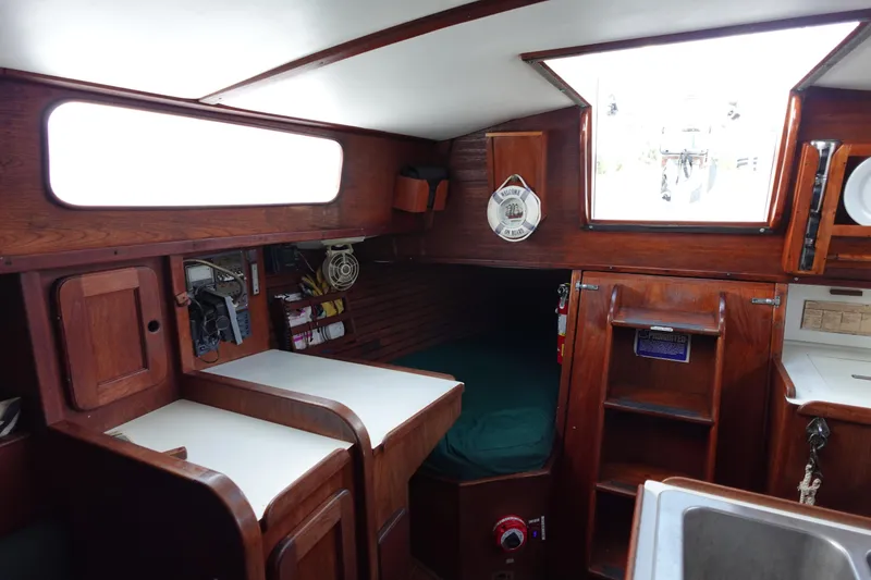 Slide: The Image of 1982 Morgan 383 sailboat interior with wood finish, compact cabin, and storage spaces. - 24