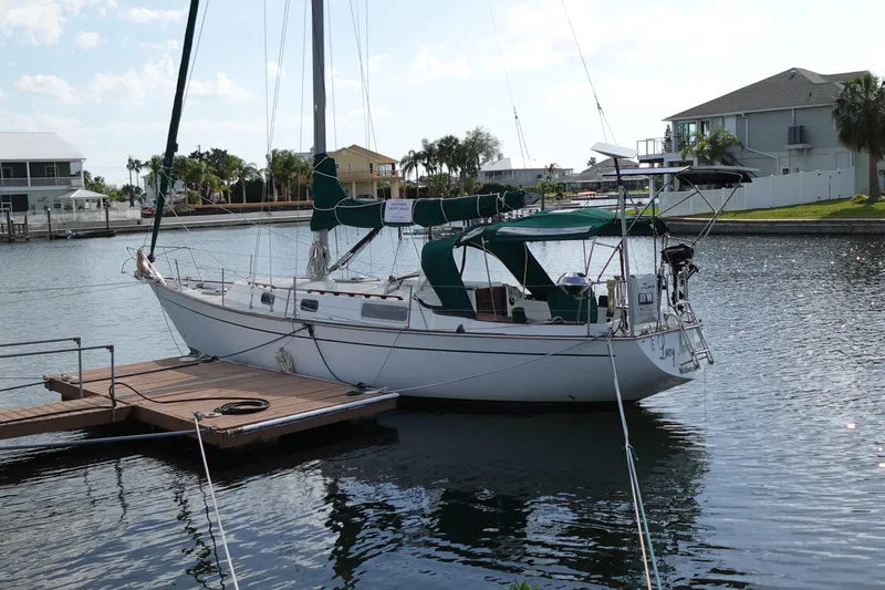 Slide: The Image of 1982 Morgan 383 sailboat docked in a serene marina setting. - 3
