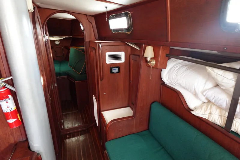 Slide: The Image of Interior of a 1982 Morgan 383 sailboat with wooden furnishings and green seating. - 37