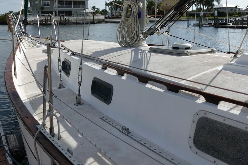 Slide: The Image of 1982 Morgan 383 sailboat deck with rigging, docked in a marina. - 4