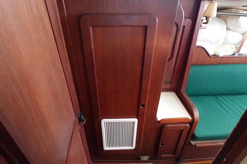 Slide: The Image of 1982 Morgan 383 yacht interior with wooden paneling and green cushioned seating. - 40