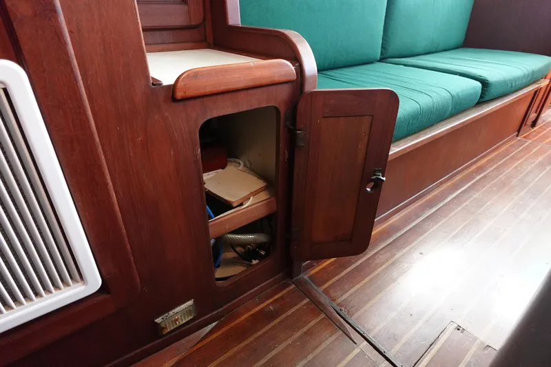 Slide: The Image of Interior of 1982 Morgan 383 sailboat with wooden cabinetry and green cushioned seating. - 42