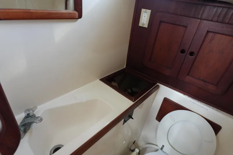 Slide: The Image of 1982 Morgan 383 yacht bathroom with sink, toilet, and wooden cabinets. - 45