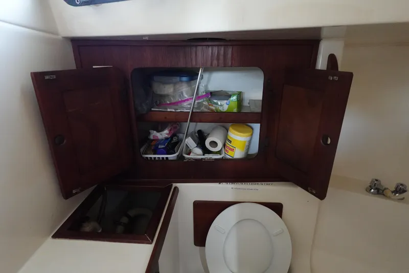Slide: The Image of 1982 Morgan 383 yacht bathroom with open wooden cabinets and toilet. - 46