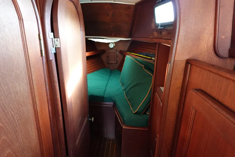 Slide: The Image of 1982 Morgan 383 yacht interior with wooden finish and green cushions. - 47