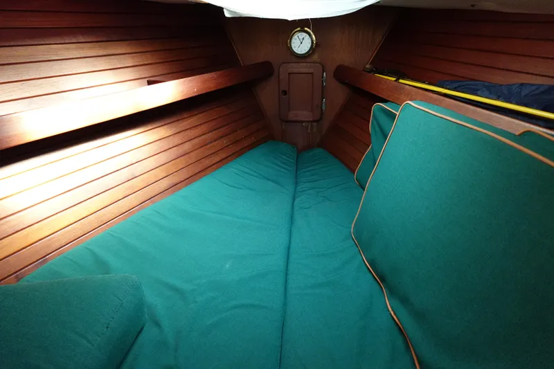 Slide: The Image of 1982 Morgan 383 cabin interior with green cushions and wooden paneling. - 48