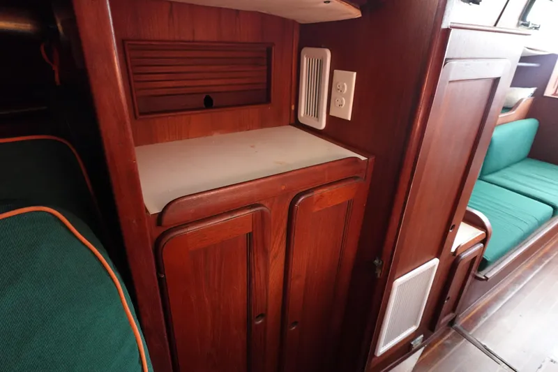 Slide: The Image of 1982 Morgan 383 yacht interior with wooden cabinetry and green seating. - 49