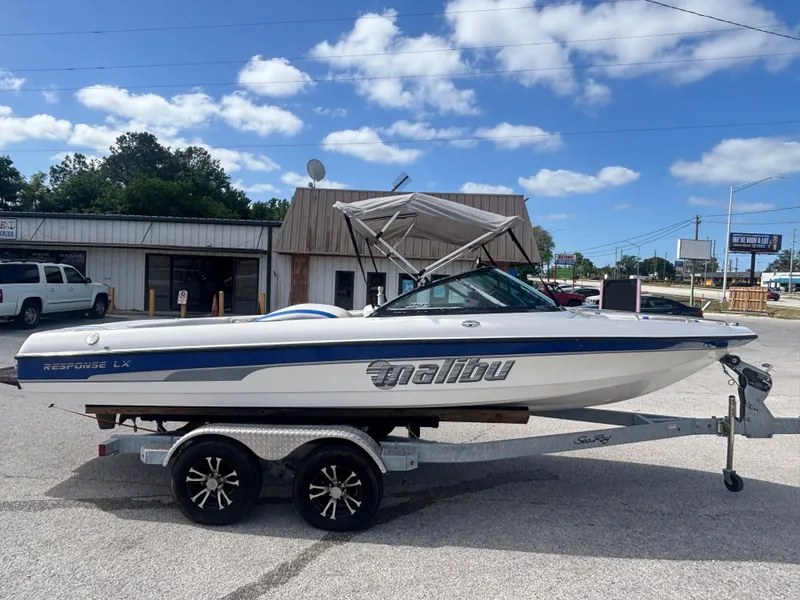 Slide: The Image of 2001 Malibu Response LX boat on trailer, parked outdoors under a clear blue sky. - 1