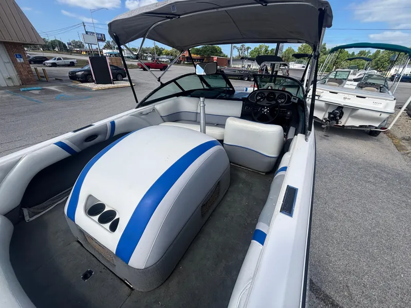 Slide: The Image of 2001 Malibu Response LX boat interior with blue and white seating, parked outdoors. - 15