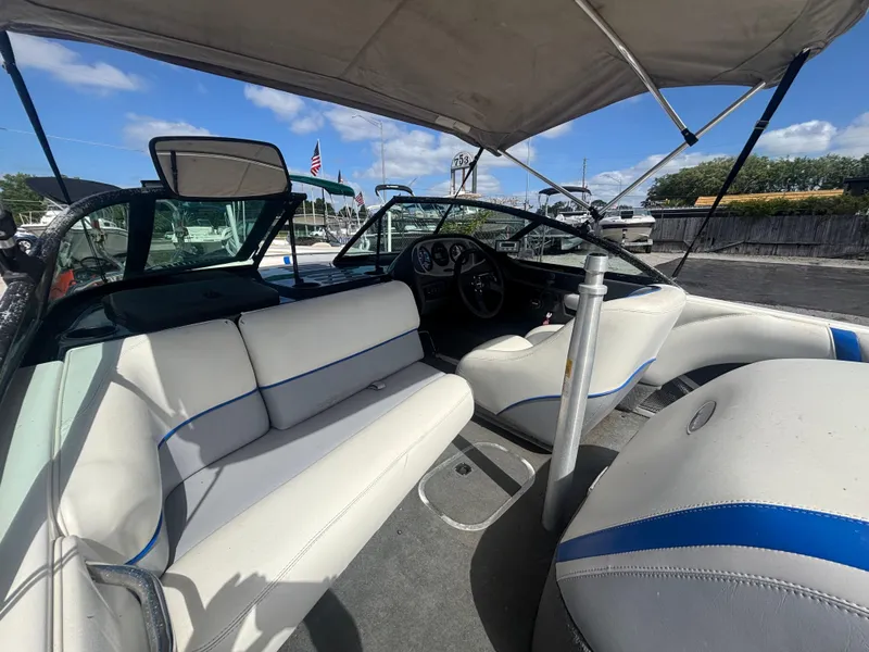 Slide: The Image of 2001 Malibu Response LX boat interior with white seating and canopy, parked at marina. - 27