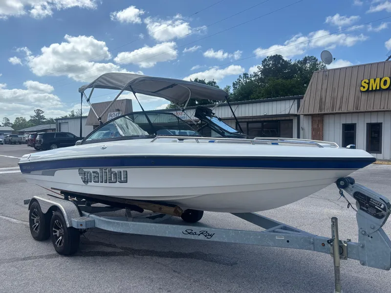 Slide: The Image of 2001 Malibu Response LX boat on trailer, parked outdoors under a partly cloudy sky. - 4