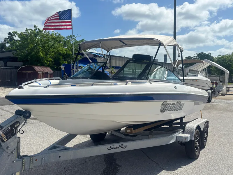 Slide: The Image of 2001 Malibu Response LX boat on trailer, American flag in background, sunny day. - 6