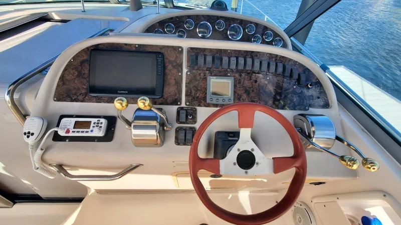 Slide: The Image of Helm of 2001 Sea Ray 310 Sundancer with steering wheel and navigation controls. - 14