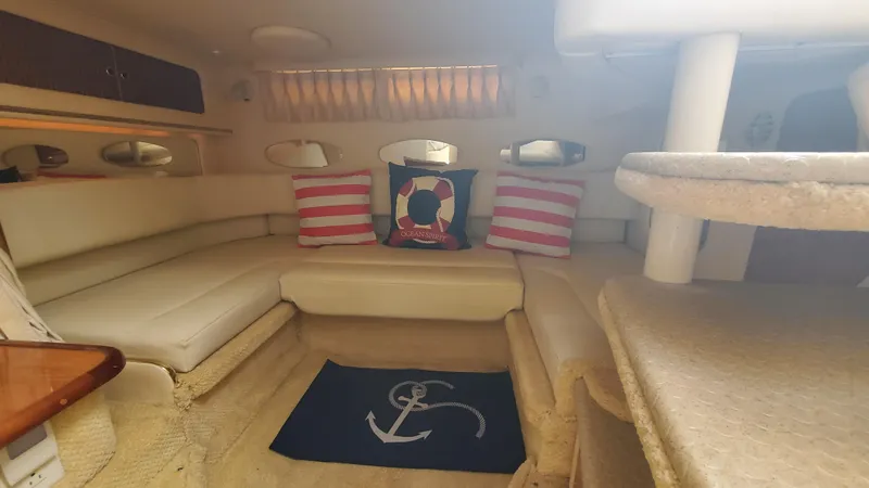 Slide: The Image of Interior of 2001 Sea Ray 310 Sundancer with nautical-themed cushions and anchor rug. - 22