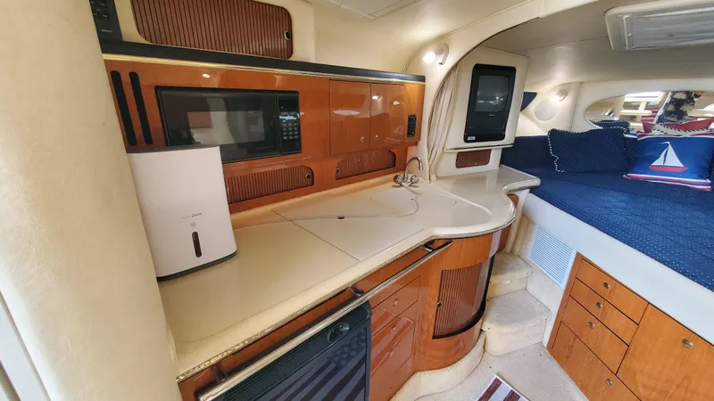 Slide: The Image of 2001 Sea Ray 310 Sundancer interior with kitchenette and sleeping area. - 24