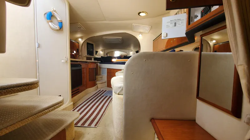 Slide: The Image of 2001 Sea Ray 310 Sundancer cabin interior with cozy seating and nautical decor. - 26