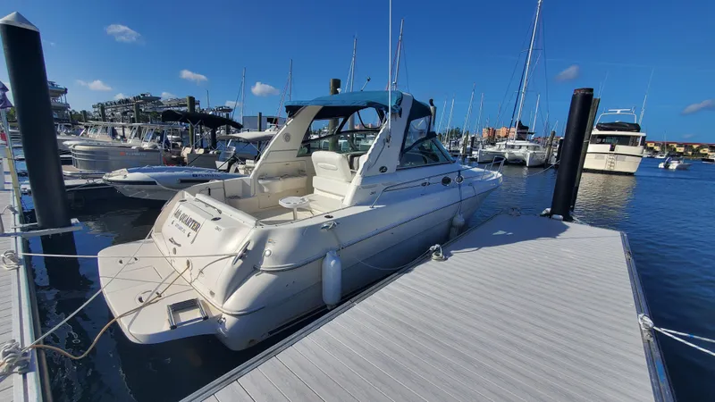 Slide: The Image of 2001 Sea Ray 310 Sundancer docked at marina under clear blue sky. - 3
