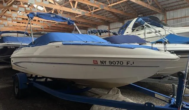 Slide: The Image of 2006 Glastron MX 195 boat with blue cover in storage facility. - 0