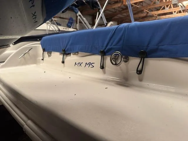 Slide: The Image of 2006 Glastron MX 195 boat with blue cover in storage. - 2