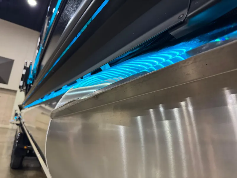 Slide: The Image of 2025 Premier 250 Solaris Rear Social boat with sleek metallic finish and blue LED lighting. - 11