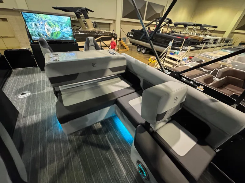 Slide: The Image of 2025 Premier 250 Solaris Rear Social pontoon boat interior at a showroom display. - 25
