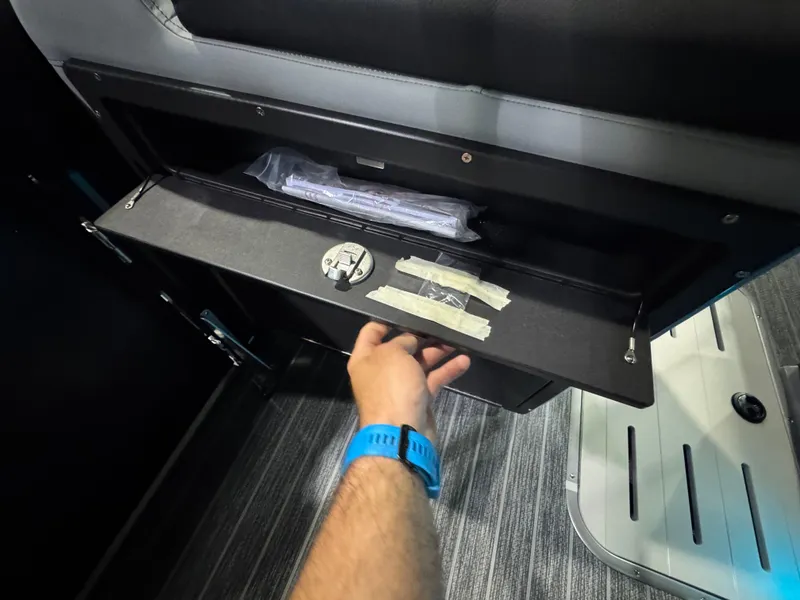 Slide: The Image of Hand opening storage compartment in 2025 Premier 250 Solaris Rear Social boat. - 33