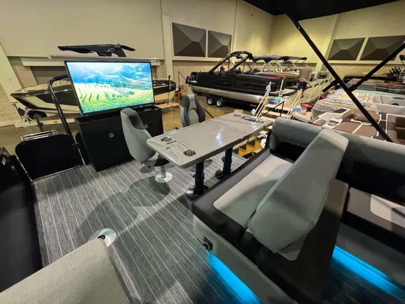 Slide: The Image of 2025 Premier 250 Solaris Rear Social boat interior with seating, table, and large screen display. - 39