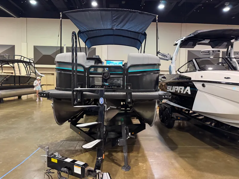 Slide: The Image of 2025 Premier 250 Solaris Rear Social pontoon boat displayed indoors. - 4