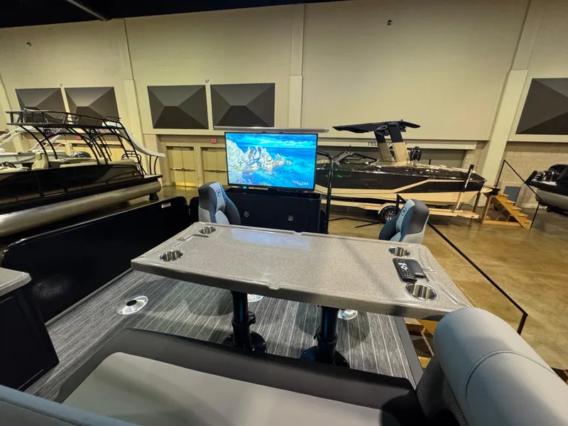 Slide: The Image of 2025 Premier 250 Solaris Rear Social boat interior with table and screen in showroom. - 41