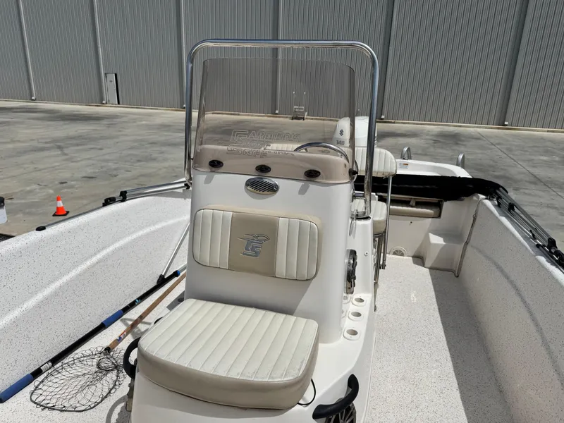 Slide: The Image of 2019 Carolina Skiff 218 DLV boat with center console and seating, docked outdoors. - 10