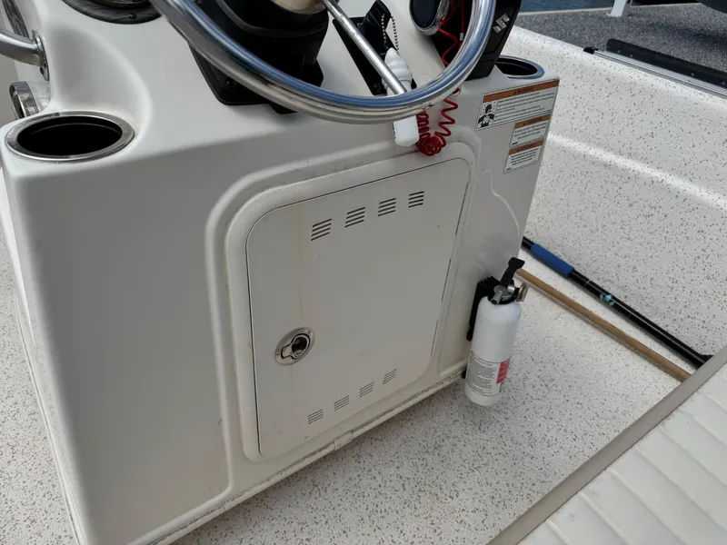 Slide: The Image of 2019 Carolina Skiff 218 DLV boat console with steering wheel and fire extinguisher. - 14
