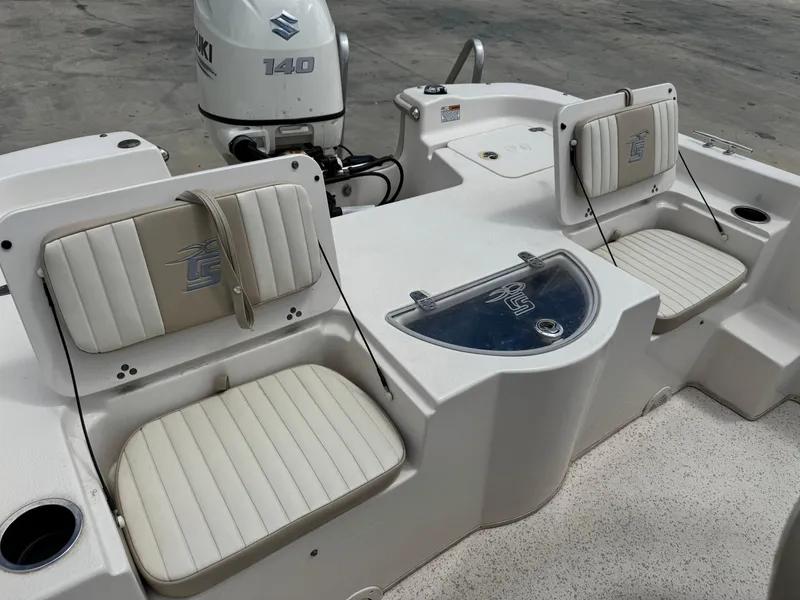 Slide: The Image of 2019 Carolina Skiff 218 DLV boat interior with Suzuki 140 engine, featuring cushioned seating. - 16