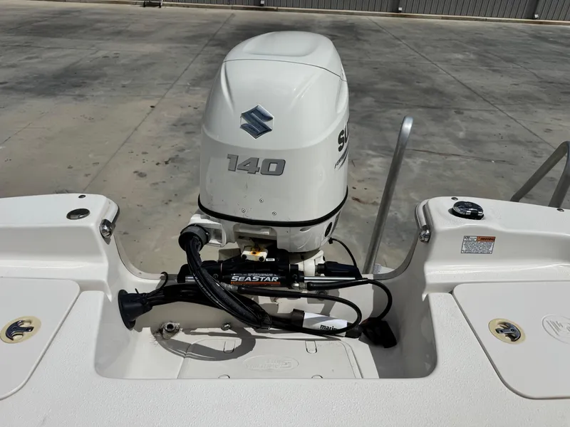 Slide: The Image of 2019 Carolina Skiff 218 DLV with Suzuki 140 outboard motor, docked on concrete surface. - 17