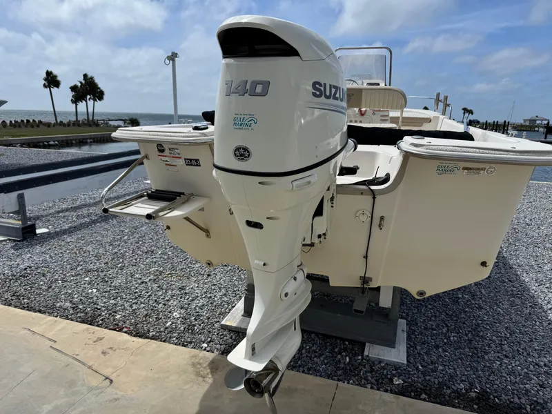 Slide: The Image of 2019 Carolina Skiff 218 DLV with Suzuki 140 outboard motor, docked by the waterfront. - 8