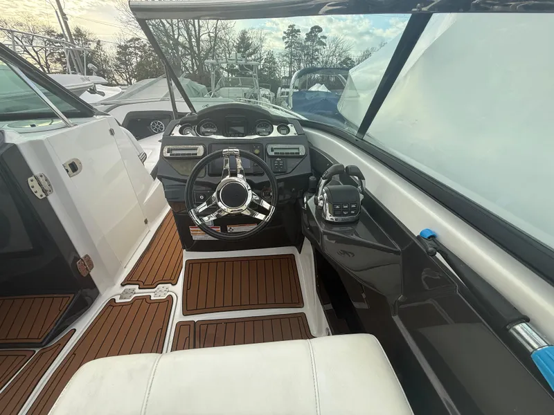 Slide: The Image of 2018 Monterey 298 Super Sport boat interior with sleek dashboard and wooden flooring. - 12